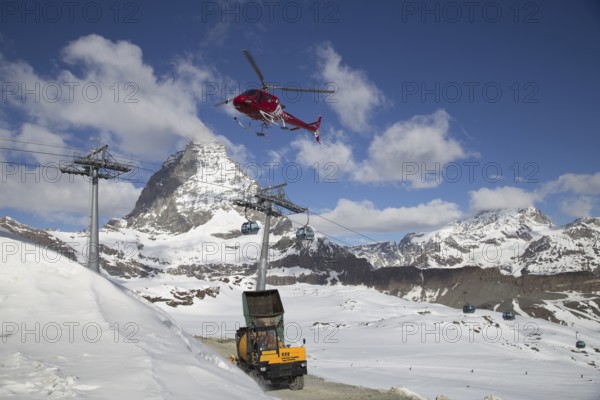 Zermatt, Switzerland, April 13, 2017: A helicopter loading concrete at a construction site in the Swiss mountains, Europe