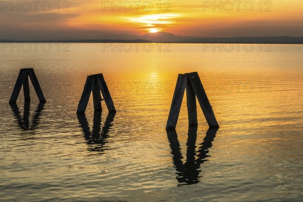 Evening atmosphere at the lake at sunset, bollard in Lake Neusiedl, Podersdorf, Burgenland, Austria, Europe