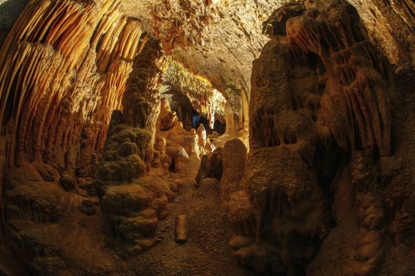 Colossal system of underground caves in Slovenia. Postojna Cave. Fantastically lit underground palaces with stalactites and stalagmites. Limestone plateau