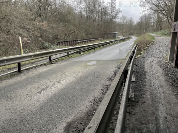 Unused industrial road in poor condition in the rain
