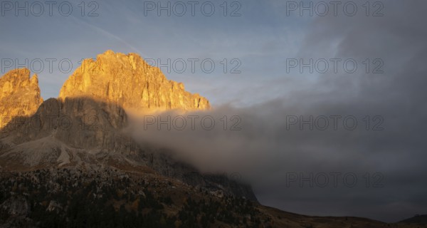 Foggy rocky mountain landscape at sunrise with blue sky. of the Dolomites at Passo Sella South Tyrol in Italy