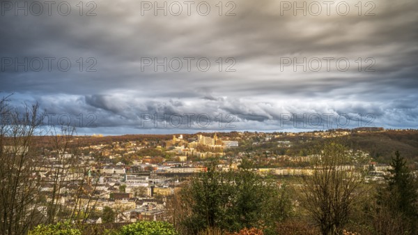 A wide cityscape under a dramatic cloudy sky in an autumnal mood, view of the Bergische Universität and Wuppertal Elberfeld