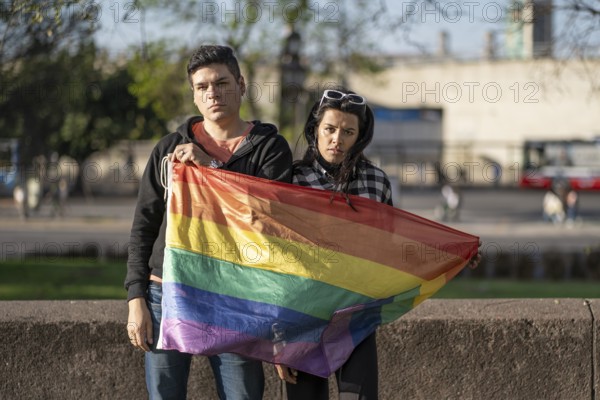 LGBT couple holding LGBT raiwbow flag