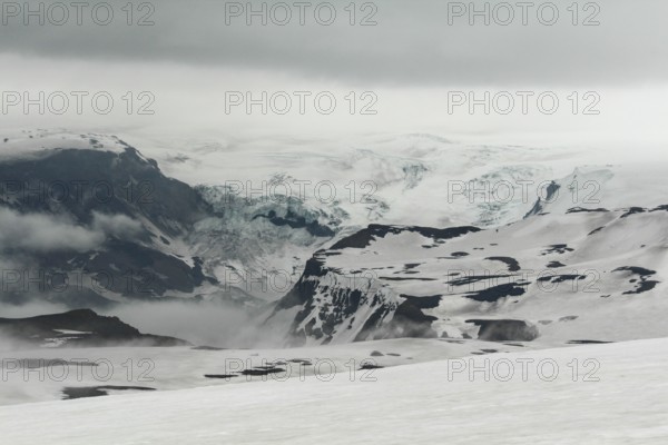 Snowy and foggy white landscape at Fimmvorduhals hiking trail, a glacier in the background, Iceland, Europe
