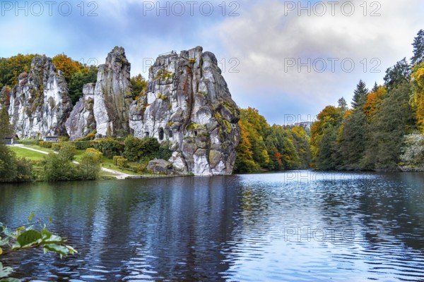 The 40 metre high Externsteine form a striking natural monument in a tranquil nature reserve in Germany. Surrounded by autumnal colours, the reflections of the rocks and foliage create a picturesque scene on the lake