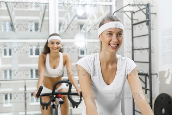 Small group of young people exercising on bikes in fitness center