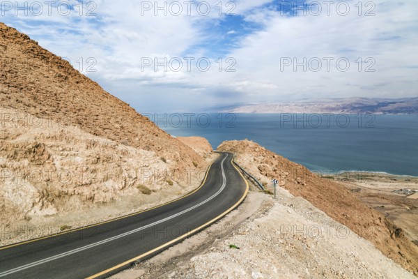 Gorgeous paved road along the seashore. The most salty sea on earth - Dead Sea. The Judean Desert is one of the most famous deserts in the world. Israel, winter cloudy day