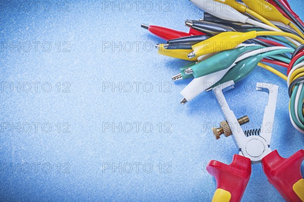 Cable crocodiles insulation strippers on blue background electricity concept