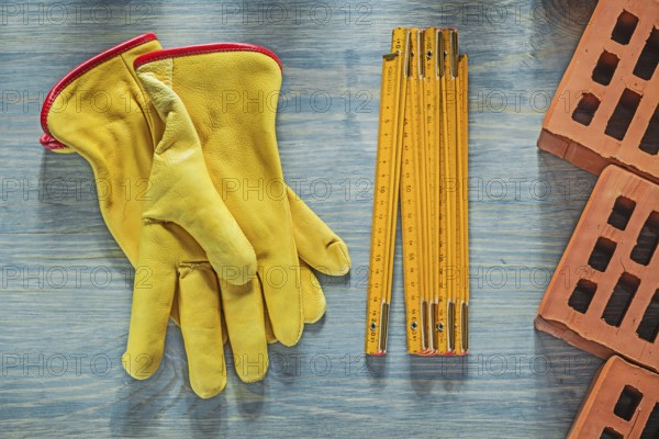 Leather safety gloves red bricks wooden meter on wood board bricklaying concept