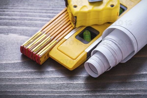 Tape-measure blueprints construction level and wooden meter on vintage wood board close up image maintenance concept