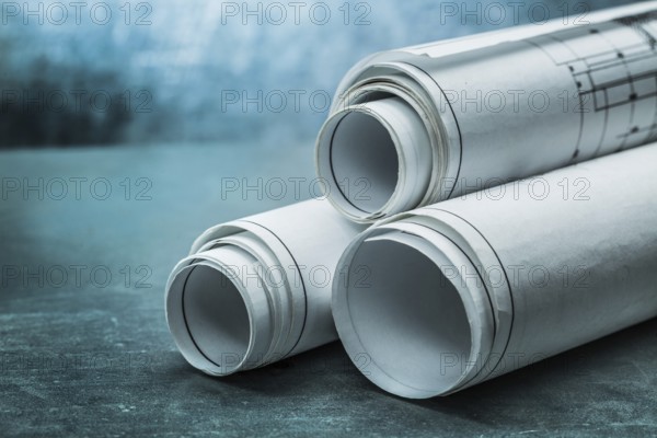 Rolls of blueprints on metalic background