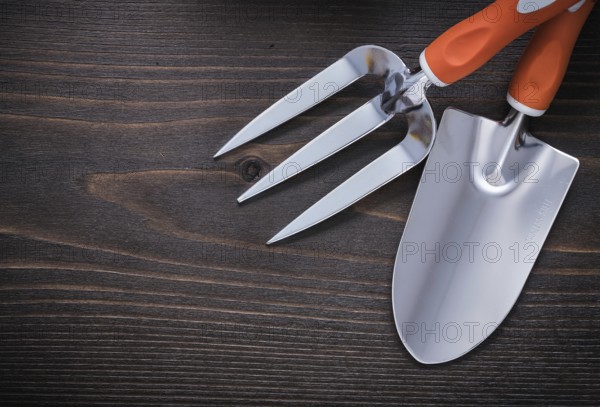 Trowel gardening fork and hand shovel on vintage wooden board agriculture concept