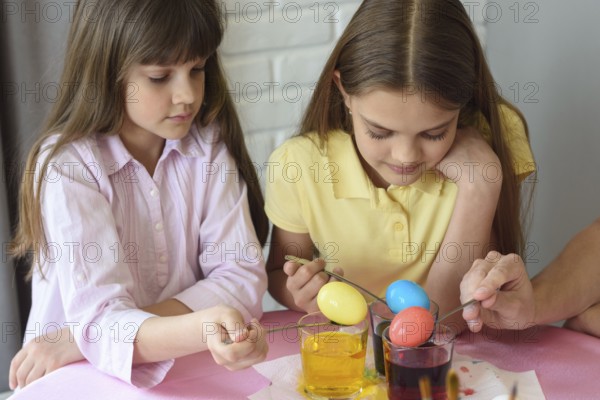 Children stain eggs in a special dye in glasses