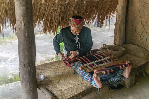 Old woman sew in traditional tribal dress