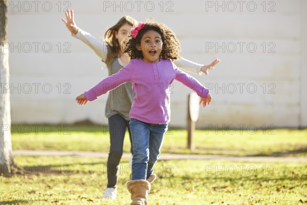 Multi ethnic kid girls playing running in park outdoor