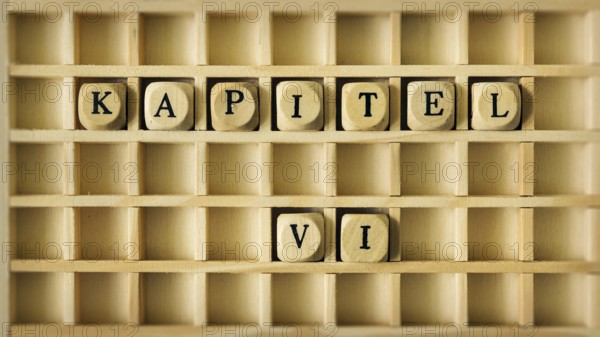An image of a wooden game with the word chapter six in german language