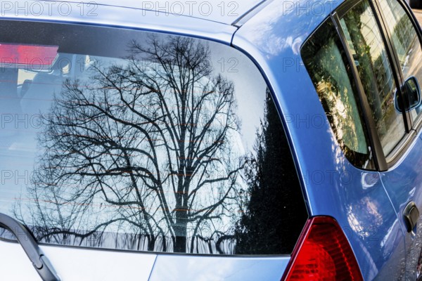 Baum spiegelt sich im Autofenster, Symbol für Natur und Technik, Kontrast, künstlich versus natürlich, Österreich
