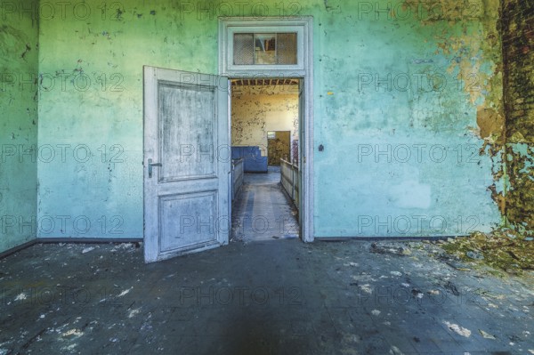 Open wooden door in a dilapidated room with peeling green wall paint, Prison H11, Lost Place, Verviers, Province of Liège, Belgium, Europe