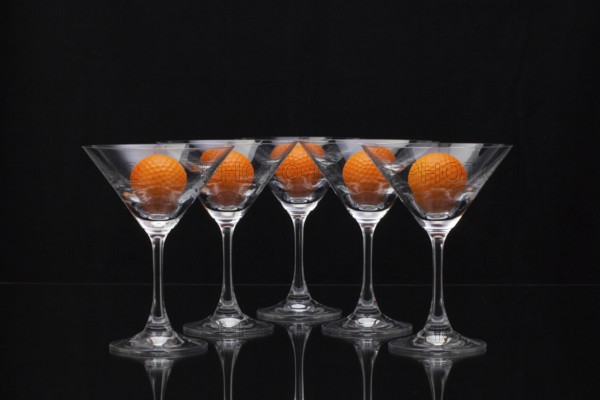 Five glasses of champagne with golf balls