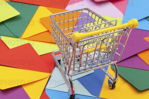 Shopping trolley and different colored envelopes on the table