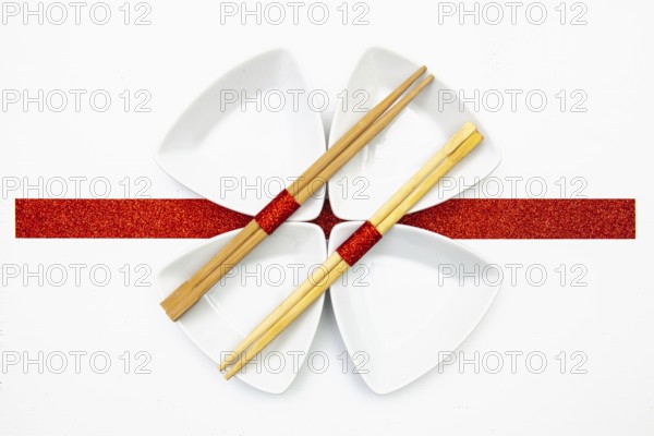 Ceramic bowls and bamboo chopsticks for sushi food with red and white decoration