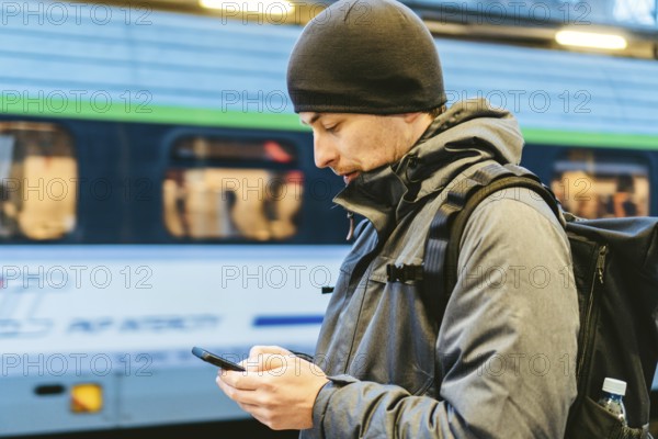 Train Station in Sopot, Poland, Europe. Attractive man waiting at the train station. Thinking about trip, with backpack. Travel photography. tourist with backpack stand on railway station platform, Europe