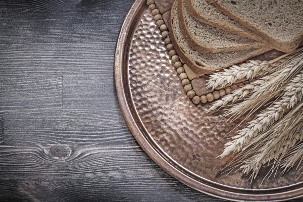 Golden rye wheat ears slices of brown bread vintage brass tray food and drink concept