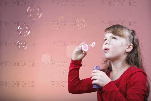 A little girl blowing soap bubbles
