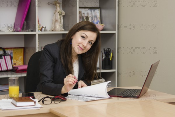 Cute business woman in the office at the computer