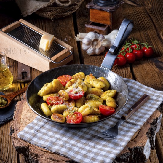 Gnocchi baked with green pesto, cherry tomatoes and parmesan