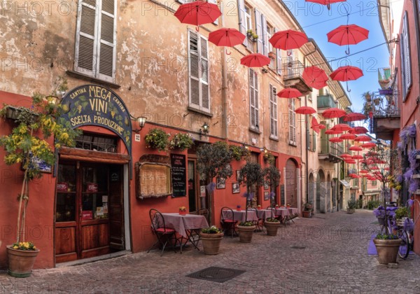 Luino, Italy, 16 March, 2023: cobblestone street with small shops and colorful decorations in the old city center of Luino, Europe