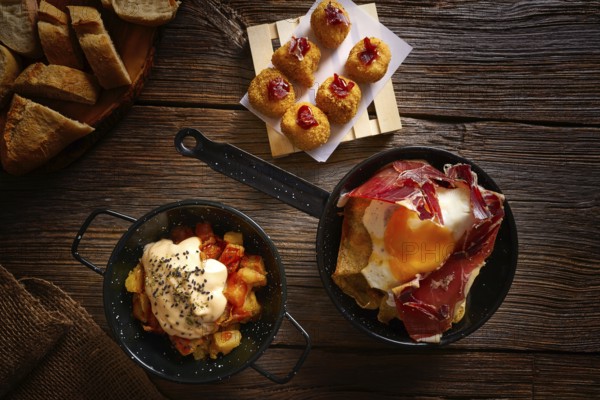 Tapas of Spain broken eggs Croquettes and Bravas potatoes