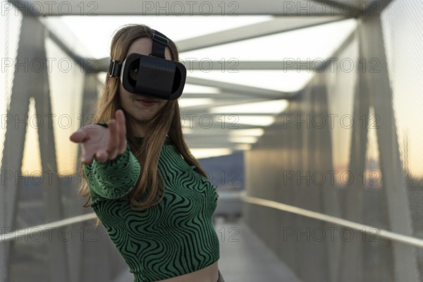 Young hispanic woman wearing in virtual reality goggles, touch something like push click on button, pointing at floating virtual screen outdoors. People sincere emotions, lifestyle concept