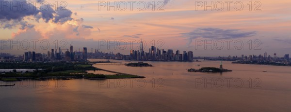 Three cities can be seen in this view of Hudson Bay at dusk with the Statue of Liberty Visable