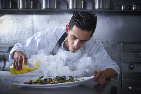 Chef working in kitchen with smoke and oil at restaurant
