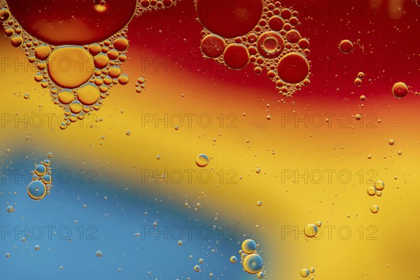 Abstract, image of oil, water and soap in a glass bowl with colourful background