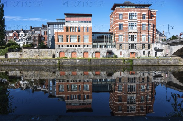 Namur, Wallon Region, Belgium, 07 28 2022, Historical buildings reflecting in the blue water of the River Sambre, Europe