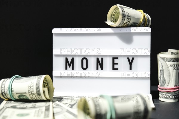 Lightbox board with the word MONEY in black letters around Us dollars banknotes. Finance background. Business, financial success and making money concept. Business budget of wealth and prosperity finance. USD Dollars Cash Bill