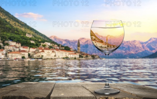 Wineglass on old wooden table on a background of Perast, Montenegro, Europe