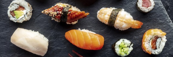 Sushi overhead flat lay panorama. Rolls, maki, nigiri on a black background, Japanese food. Salmon, eel, shrimp and other seafood with rice on a plate at an Asian restaurant, Food photography, Food photography
