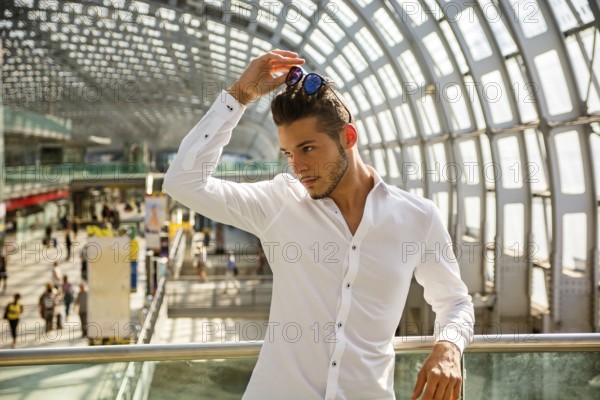 Handsome young man in train station or airport looking away
