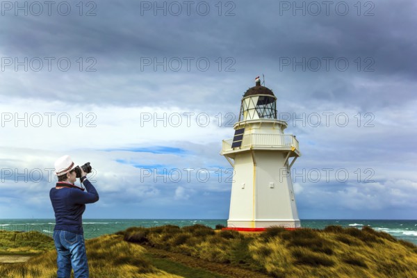 Independent trip to New Zealand. The snow-white lighthouse of Waipapa is visible on the horizon. Scenic South Island on a cloudy windy day. The concept of ecological, active and photo tourism