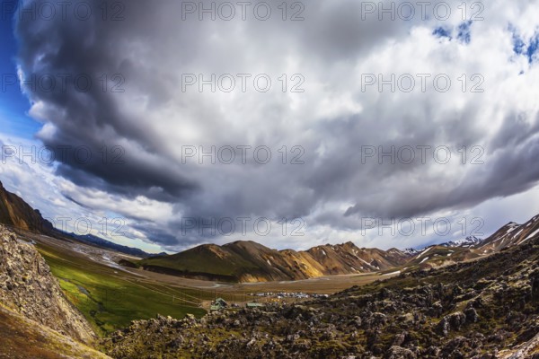 Travel to Iceland in July, volcanic summer tundra. Multi-colored rhyolite mountains - orange, yellow, green and blue. The picture was taken Fisheye lens