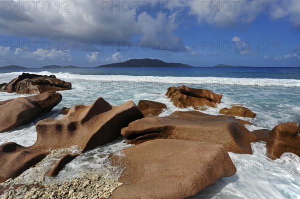 Granite rocks washed out in the water at Anse Banane, La Digue Island, behind the island Felicite, the Seychelles, Indian Ocean
