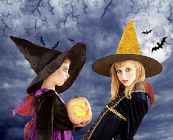 Halloween kid girls and pumpkin on cloudy moon sky