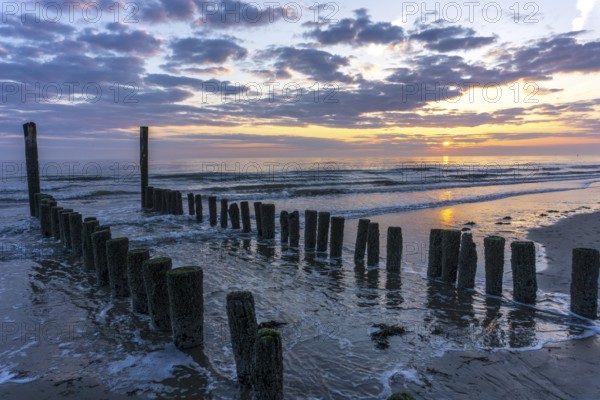 Beautiful Sunset at the seaside in the Netherlands with strong colours in the clouds and the water