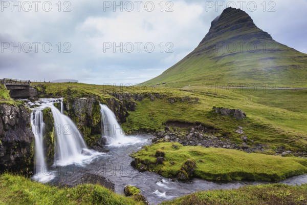 Cascade deep falls on the grassy mountains. Iceland - the country of mountains, the rivers and falls