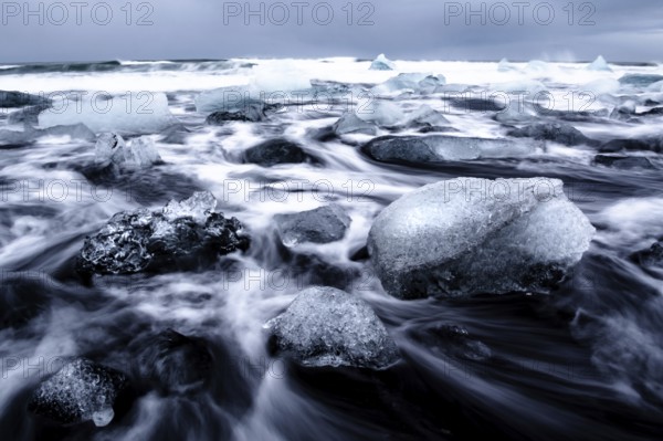 Dramatic seascape with floating blocks of ice and wild waves, Diamond Beach, Iceland, Europe