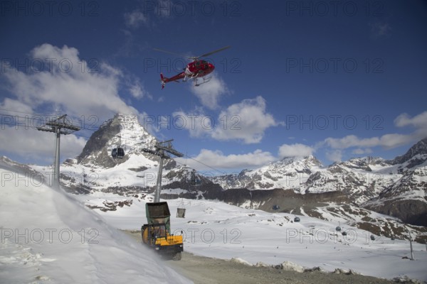 Zermatt, Switzerland, April 13, 2017: A helicopter loading concrete at a construction site in the Swiss mountains, Europe