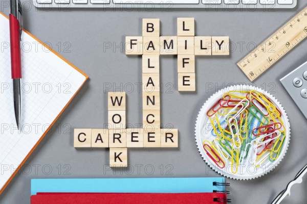 Business motivation concept with words from cubes. Still life of office workplace with crossword. Flat lay grey surface with notebook and stationery. Strategy planning and business analytics